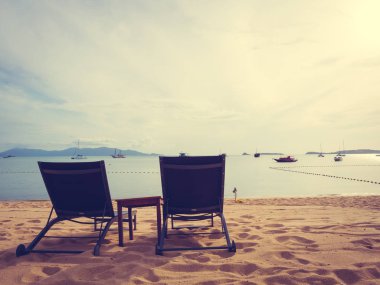 Şemsiye ve tropikal plaj deniz ve okyanus gündoğumu zaman seyahat ve tatil için sandalye