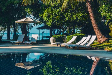Güzel lüks otel ve tatil seyahat ve tatil için sandalye ve şemsiye ile açık yüzme havuzu