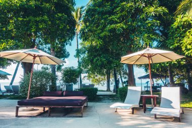 Güzel lüks otel ve tatil seyahat ve tatil için sandalye ve şemsiye ile açık yüzme havuzu