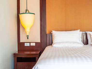 Otel yatak odasında ışık lamba dekorasyonu ile yatakta rahat yastık