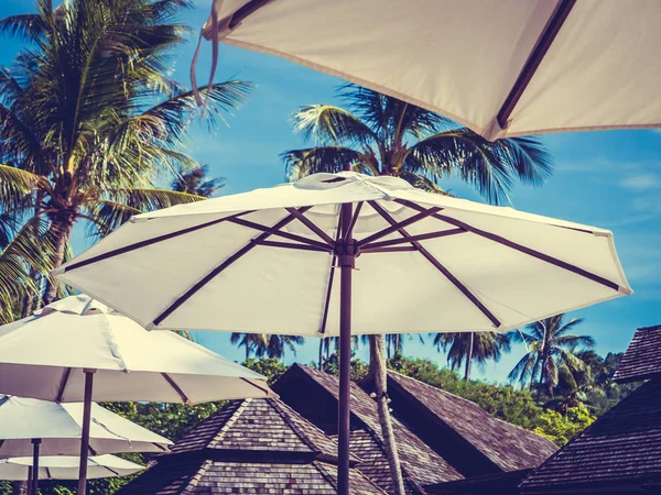 Hindistan cevizi hurma ağacı ile deniz okyanus seyahat ve tatil için mavi gökyüzü arka plan üzerinde Beyaz şemsiye