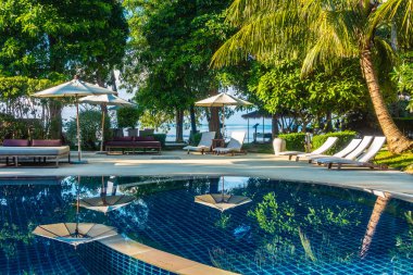Güzel lüks otel ve tatil seyahat ve tatil için sandalye ve şemsiye ile açık yüzme havuzu