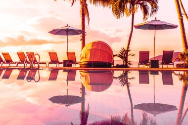 Şemsiye ve lüks otel ve gündoğumu zaman seyahat ve tatil için Resort'ta yüzme havuzu etrafında sandalye ile güzel açık görünüm