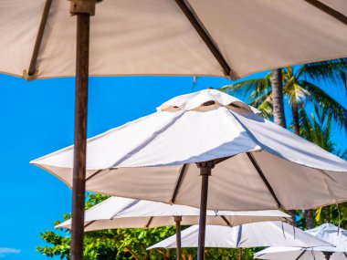 Hindistan cevizi hurma ağacı ile deniz okyanus seyahat ve tatil için mavi gökyüzü arka plan üzerinde Beyaz şemsiye