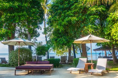 Güzel lüks otel ve tatil seyahat ve tatil için sandalye ve şemsiye ile açık yüzme havuzu