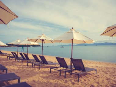 Şemsiye ve tropikal plaj deniz ve okyanus gündoğumu zaman seyahat ve tatil için sandalye