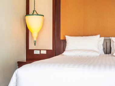 Otel yatak odasında ışık lamba dekorasyonu ile yatakta rahat yastık