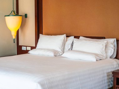 Otel yatak odasında ışık lamba dekorasyonu ile yatakta rahat yastık