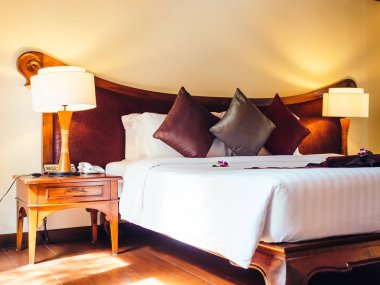 Otel yatak odasında ışık lamba dekorasyonu ile yatakta rahat yastık