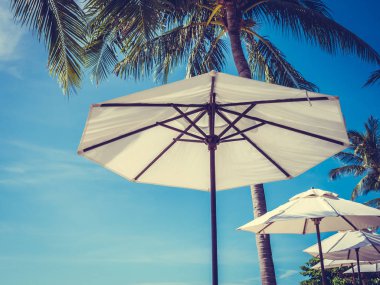 Hindistan cevizi hurma ağacı ile deniz okyanus seyahat ve tatil için mavi gökyüzü arka plan üzerinde Beyaz şemsiye