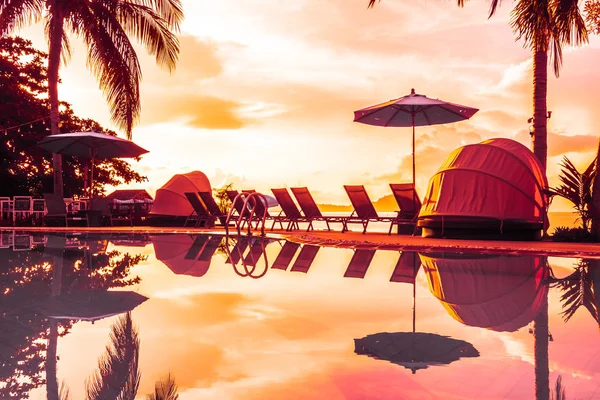 Şemsiye ve lüks otel ve gündoğumu zaman seyahat ve tatil için Resort'ta yüzme havuzu etrafında sandalye ile güzel açık görünüm