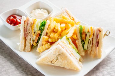 Club sandviç pastırma peynir, jambon sebze ve sos beyaz plaka ile