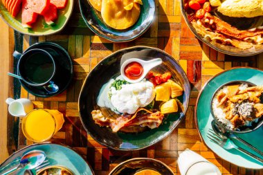 Sağlıklı kahvaltı seti yumurta pastırma ile portakal suyu süt ekmek kahve ve diğer ahşap masada krep