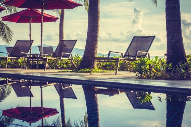 Güzel lüks otel ve tatil seyahat ve tatil için sandalye ve şemsiye ile açık yüzme havuzu