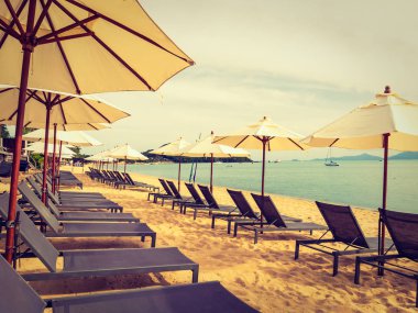 Şemsiye ve tropikal plaj deniz ve okyanus gündoğumu zaman seyahat ve tatil için sandalye