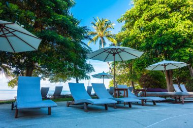 Güzel lüks otel ve tatil seyahat ve tatil için sandalye ve şemsiye ile açık yüzme havuzu