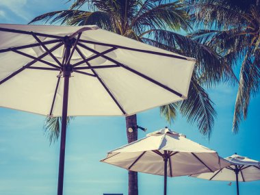 Hindistan cevizi hurma ağacı ile deniz okyanus seyahat ve tatil için mavi gökyüzü arka plan üzerinde Beyaz şemsiye