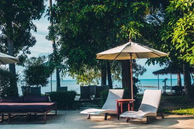 Güzel lüks otel ve tatil seyahat ve tatil için sandalye ve şemsiye ile açık yüzme havuzu