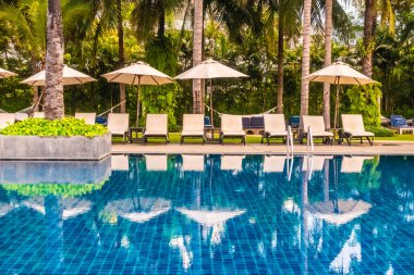 Güzel lüks otel ve tatil seyahat ve tatil için sandalye ve şemsiye ile açık yüzme havuzu