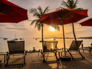 Şemsiye ve sandalye açık yüzme havuzunda otel ve gündoğumu zaman resort çevresinde