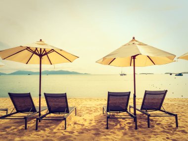 Şemsiye ve tropikal plaj deniz ve okyanus gündoğumu zaman seyahat ve tatil için sandalye