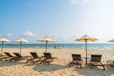 Şemsiye ve güzel plaj ve deniz - tatil kavramı üzerinde sandalye