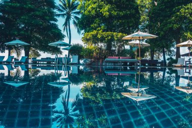 Güzel lüks otel ve tatil seyahat ve tatil için sandalye ve şemsiye ile açık yüzme havuzu