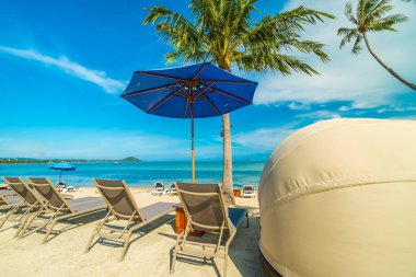 Güzel tropikal plaj ve Hindistan cevizi hurma ağacı ve şemsiye ve Cennet Adası tatil tatil için sandalyeye denize sıfır