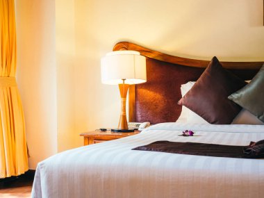 Otel yatak odasında ışık lamba dekorasyonu ile yatakta rahat yastık