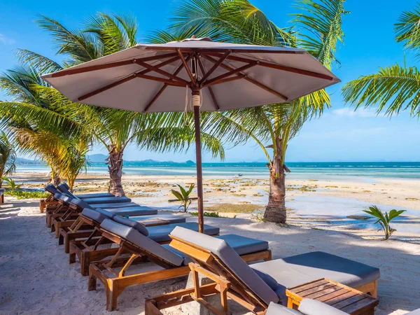 Umbrella and chair on the beach and sea ocean with blue sky around coconut palm tree for travel and vacation