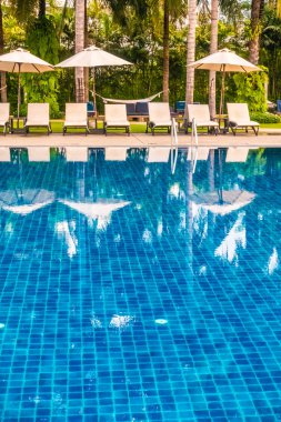 Güzel lüks otel ve tatil seyahat ve tatil için sandalye ve şemsiye ile açık yüzme havuzu