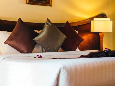 Otel yatak odasında ışık lamba dekorasyonu ile yatakta rahat yastık