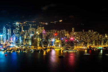 Hong Kong şehrinin dış şehir manzarası geceleri gökyüzüne yükseliyor.