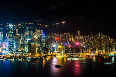 Hong Kong şehrinin dış şehir manzarası geceleri gökyüzüne yükseliyor.