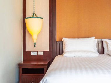 Otel yatak odasında ışık lamba dekorasyonu ile yatakta rahat yastık