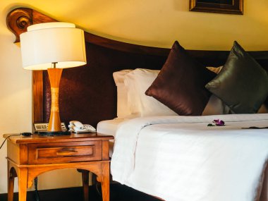 Otel yatak odasında ışık lamba dekorasyonu ile yatakta rahat yastık