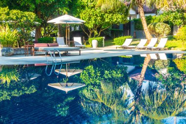 Güzel lüks otel ve tatil seyahat ve tatil için sandalye ve şemsiye ile açık yüzme havuzu