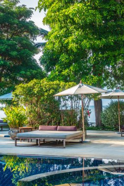 Güzel lüks otel ve tatil seyahat ve tatil için sandalye ve şemsiye ile açık yüzme havuzu