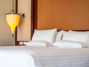 Otel yatak odasında ışık lamba dekorasyonu ile yatakta rahat yastık