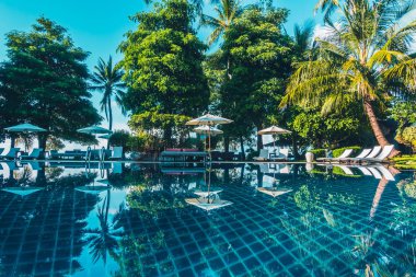 Güzel lüks otel ve tatil seyahat ve tatil için sandalye ve şemsiye ile açık yüzme havuzu