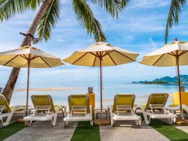 Şemsiye ve sandalye etrafında lüks otel ve resort tatil ve seyahat için açık yüzme havuzu