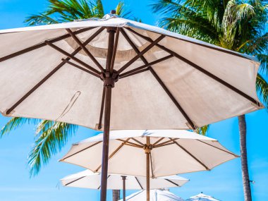 Hindistan cevizi hurma ağacı ile deniz okyanus seyahat ve tatil için mavi gökyüzü arka plan üzerinde Beyaz şemsiye