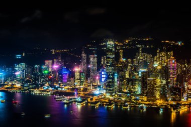 Hong Kong şehrinin dış şehir manzarası geceleri gökyüzüne yükseliyor.
