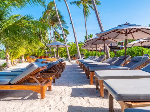 Umbrella and chair on the beach and sea ocean with blue sky around coconut palm tree for travel and vacation