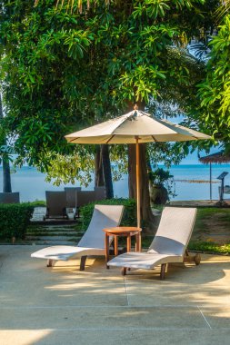 Güzel lüks otel ve tatil seyahat ve tatil için sandalye ve şemsiye ile açık yüzme havuzu