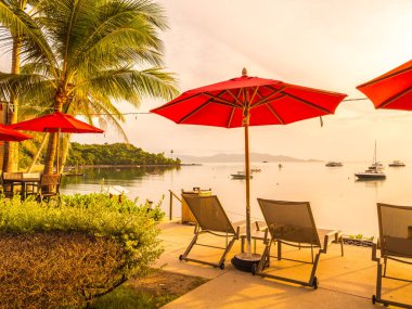 Şemsiye ve sandalye açık yüzme havuzunda otel ve gündoğumu zaman resort çevresinde