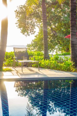 Güzel lüks otel ve tatil seyahat ve tatil için sandalye ve şemsiye ile açık yüzme havuzu