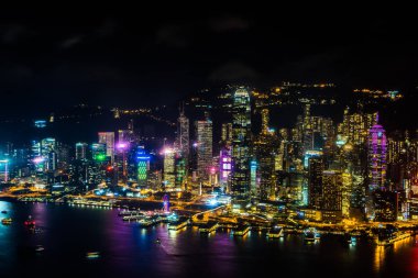 Hong Kong şehrinin dış şehir manzarası geceleri gökyüzüne yükseliyor.