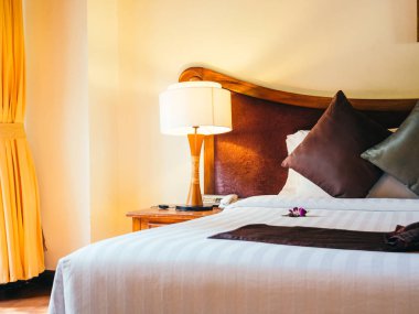 Otel yatak odasında ışık lamba dekorasyonu ile yatakta rahat yastık