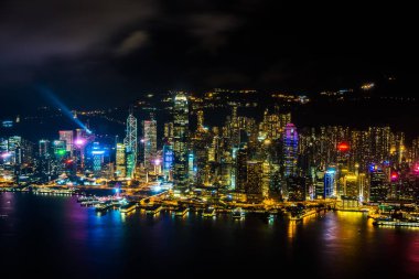 Hong Kong şehrinin dış şehir manzarası geceleri gökyüzüne yükseliyor.